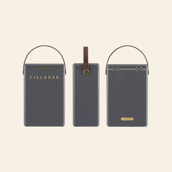 Three dark gray rectangular Fieldbar Drinks Boxes with brown handles are shown from the front, side, and back. The front displays FIELDBAR in gold, highlighting the portable cooler’s renowned thermal performance.