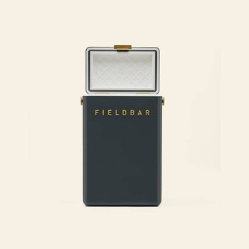A dark green Fieldbar Drinks Box by Fieldbar with gold hardware and an open white lid shows a diamond-patterned interior for thermal performance, set against a plain beige background.