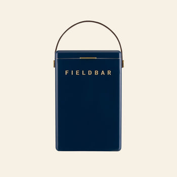 A dark blue rectangular Fieldbar Drinks Box by Fieldbar features a gold clasp, gold FIELD BAR lettering on the front, and a brown handle, celebrated for superior thermal performance, shown against a plain light background.