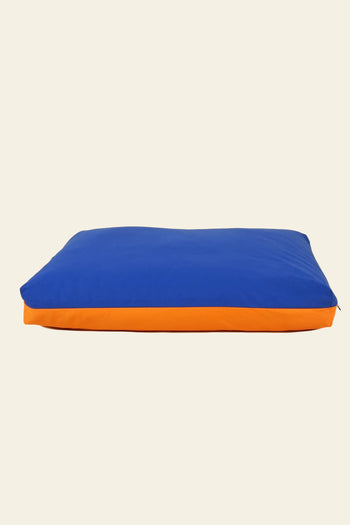 The Good Chonk Cloud Kapok Dog Bed by Good Chonk features a rectangular shape, blue top, orange side, eco-friendly kapok fill, and a 100% cotton canvas cover, displayed on a plain light background.
