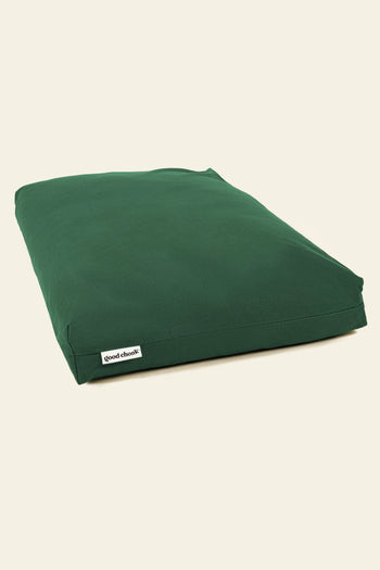 A rectangular, dark green Good Chonk Cloud Kapok Dog Bed with a 100% cotton canvas cover is shown on a plain, light background. A small white tag with the Good Chonk logo is visible on one side.