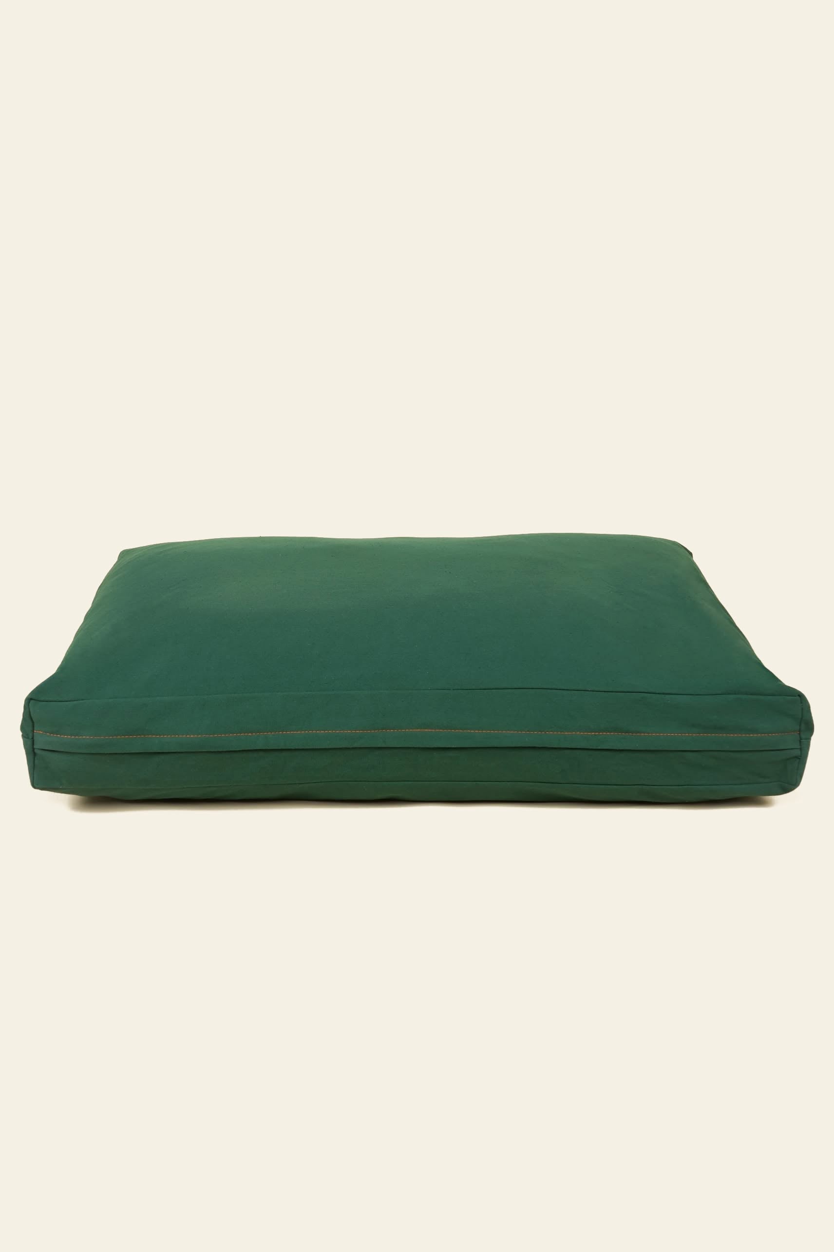 The Good Chonk Cloud Kapok Dog Bed by Good Chonk is a large, rectangular dark green bed or floor pillow with eco-friendly kapok fill and a 100% cotton canvas cover, featuring a visible seam and set against a plain beige background.