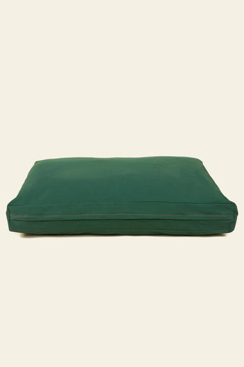 The Good Chonk Cloud Kapok Dog Bed by Good Chonk is a large, rectangular dark green bed or floor pillow with eco-friendly kapok fill and a 100% cotton canvas cover, featuring a visible seam and set against a plain beige background.