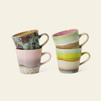 The HKLIVING 70s Ceramics: Americano Mugs, Set of 4 features hand-glazed stoneware mugs in pastel pink, green, yellow, and turquoise with earthy textures and unique designs inspired by 70s style.