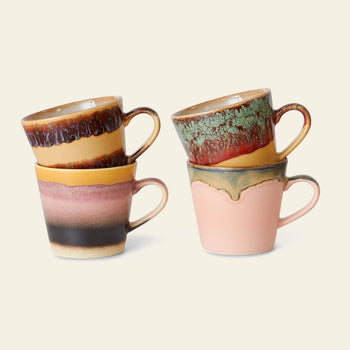 The HKLIVING 70s Ceramics: Cappuccino Mugs, Set of 4 features hand-glazed mugs with handles in earthy brown, yellow, green, pink, and black on light beige for a retro vibe—perfect stacked in pairs.