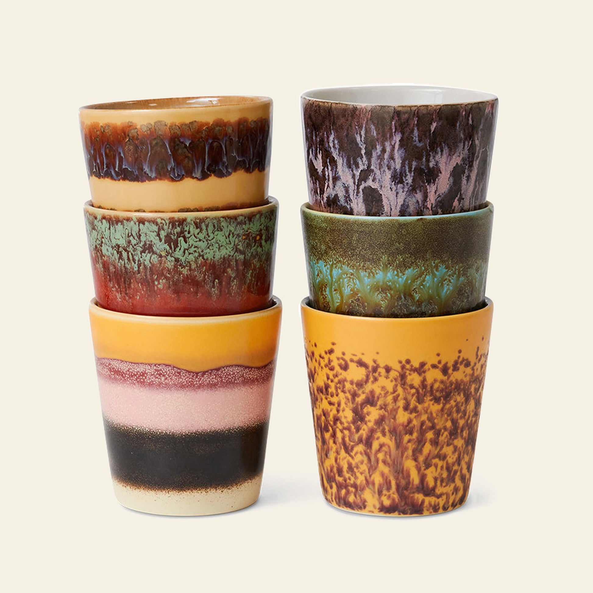 The HKLIVING 70s Ceramics Coffee Mugs, Set of 6, feature unique hand-glazed patterns and colors—browns, greens, yellows, purples, and reds—that evoke a retro 70s style. Stackable in two columns of three.