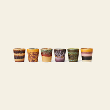 The HKLIVING 70s Ceramics Coffee Mugs, Set of 6, features colorful handcrafted mugs with unique textured and speckled glazing, beautifully arranged in a row against a plain light beige background.