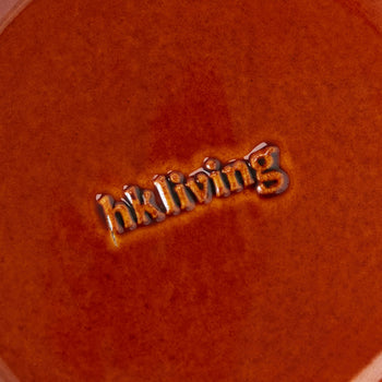 A close-up of a textured, reddish-brown ceramic dessert bowl from the HKLIVING 70s Ceramics: Dessert Bowls, Set of 4 shows the glazed, embossed HKLIVING logo at the center, highlighting its retro-inspired design.