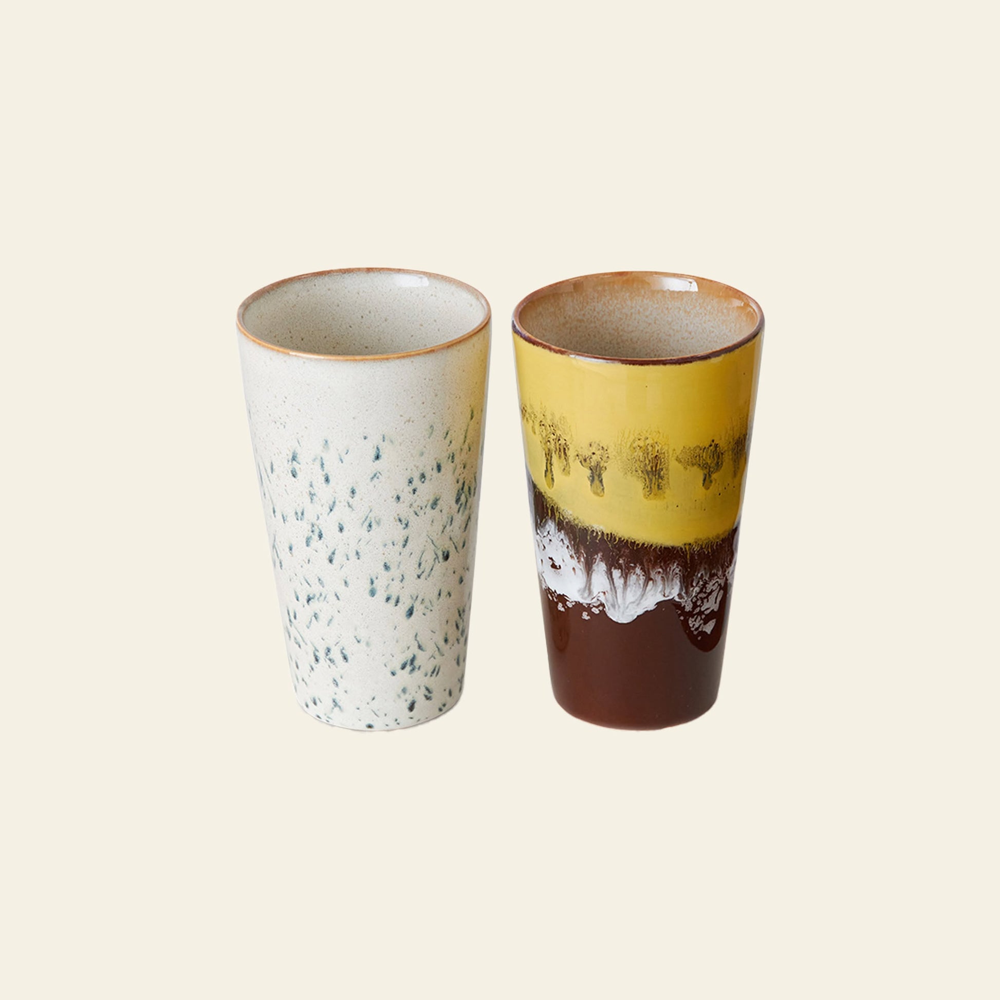 HKLIVING 70s Ceramics: Latte Mugs, Set of 2—one off-white with blue speckles, the other featuring a brown base with yellow and white handcrafted glaze—sit side by side on a light background, echoing classic 70s retro style.