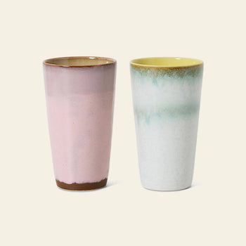 The HKLIVING 70s Ceramics: Latte Mugs, Set of 2 features handcrafted glaze details—one mug in pink with a brown base, the other in white with a blue-green gradient and yellow interior—by HKLIVING.