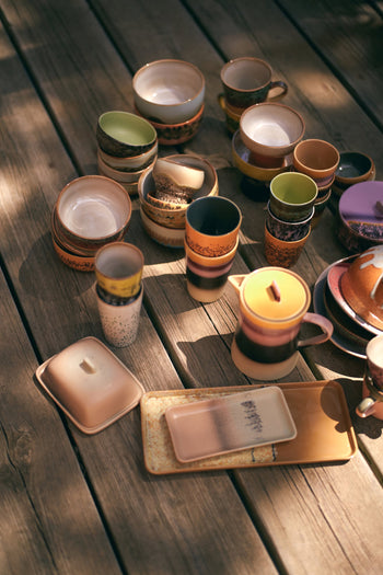 HKLIVING 70s Ceramics Tea Mugs, Set of 2 by HKLIVING, are displayed on a sun-dappled wooden deck, showcasing their classic earthy tones and vintage-inspired design.