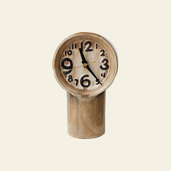 The HKLIVING Retro Ceramic Clock - Cream features distorted, melted numbers and a warped face on a cylindrical base, highlighting its vintage-inspired design by HKLIVING against an off-white backdrop.