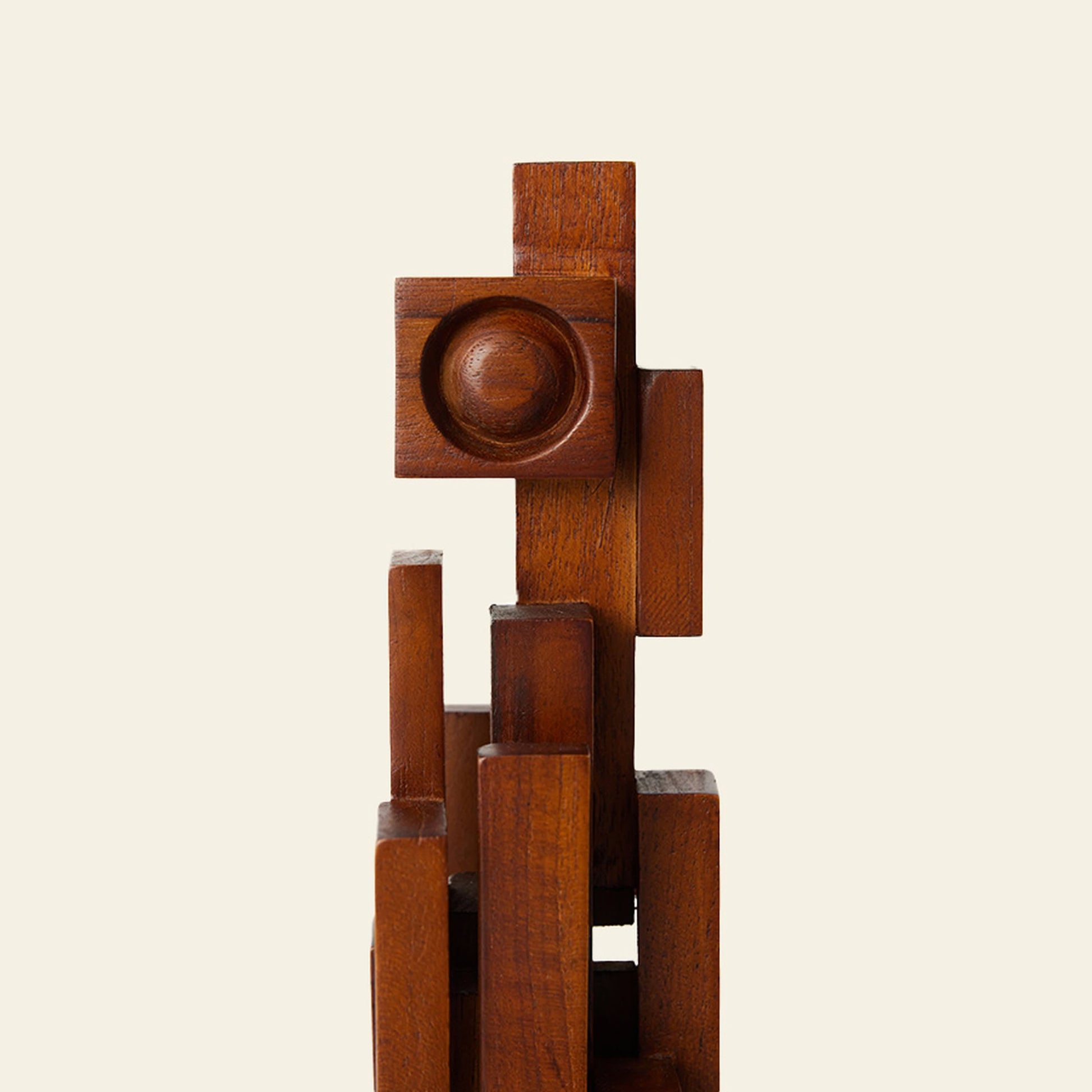 The HKLIVING Skyline Sculpture S - Espresso by HKLIVING is a wooden abstract piece crafted from teak, featuring stacked geometric shapes—rectangles and a central circular indentation—set against an off-white background.