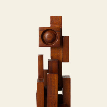 The HKLIVING Skyline Sculpture S - Espresso by HKLIVING is a wooden abstract piece crafted from teak, featuring stacked geometric shapes—rectangles and a central circular indentation—set against an off-white background.