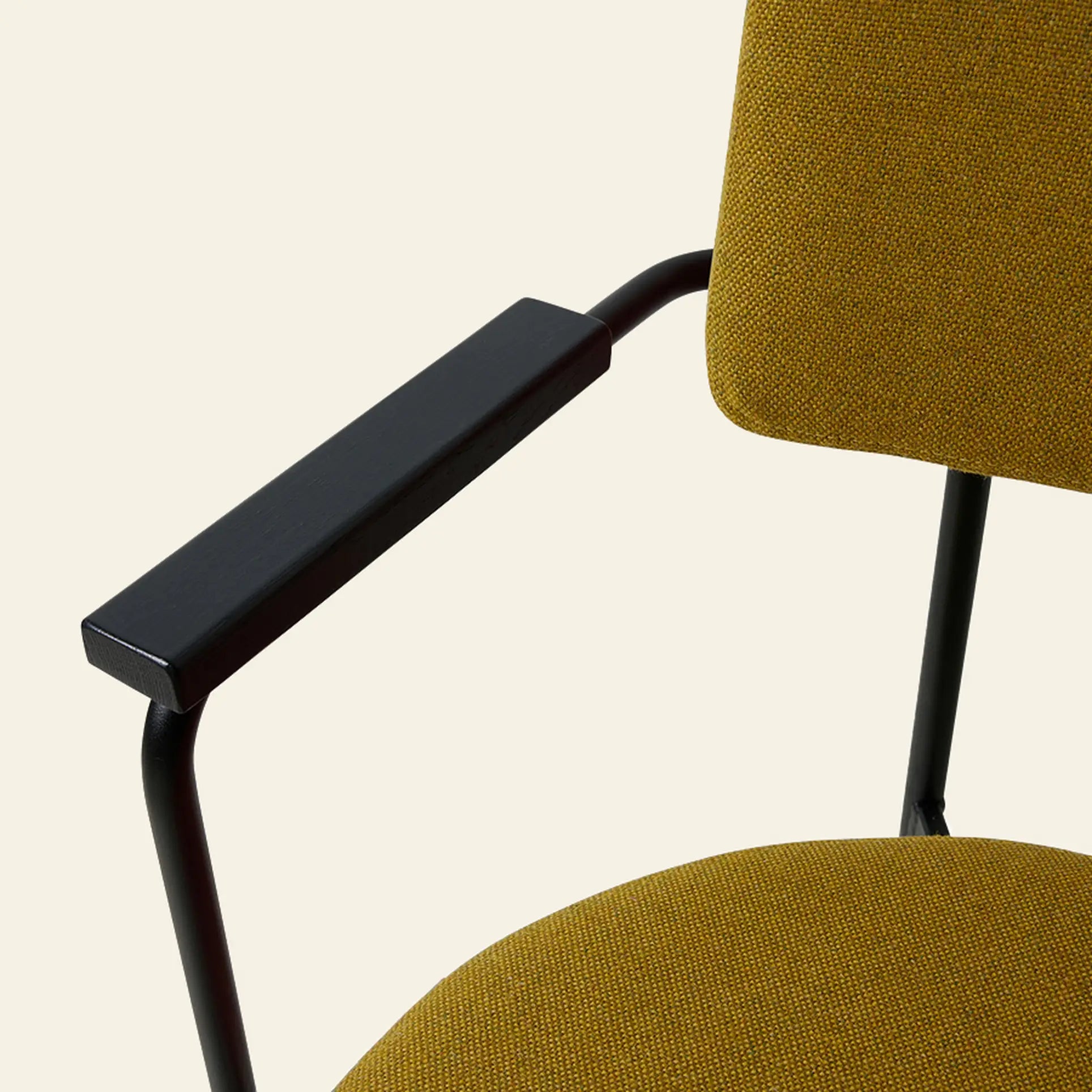 Close-up of the HKLIVING Dining Armchair in Main Line Flax mustard yellow fabric, featuring black metal armrests and frame. A modern Dutch-inspired design by HKLIVING, shown against a plain light background.