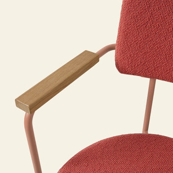 A close-up of the HKLIVING Dining Armchair, Yoredale, Nude shows its textured red upholstery, pink metal frame, and wooden armrests by HKLIVING against a light beige background.