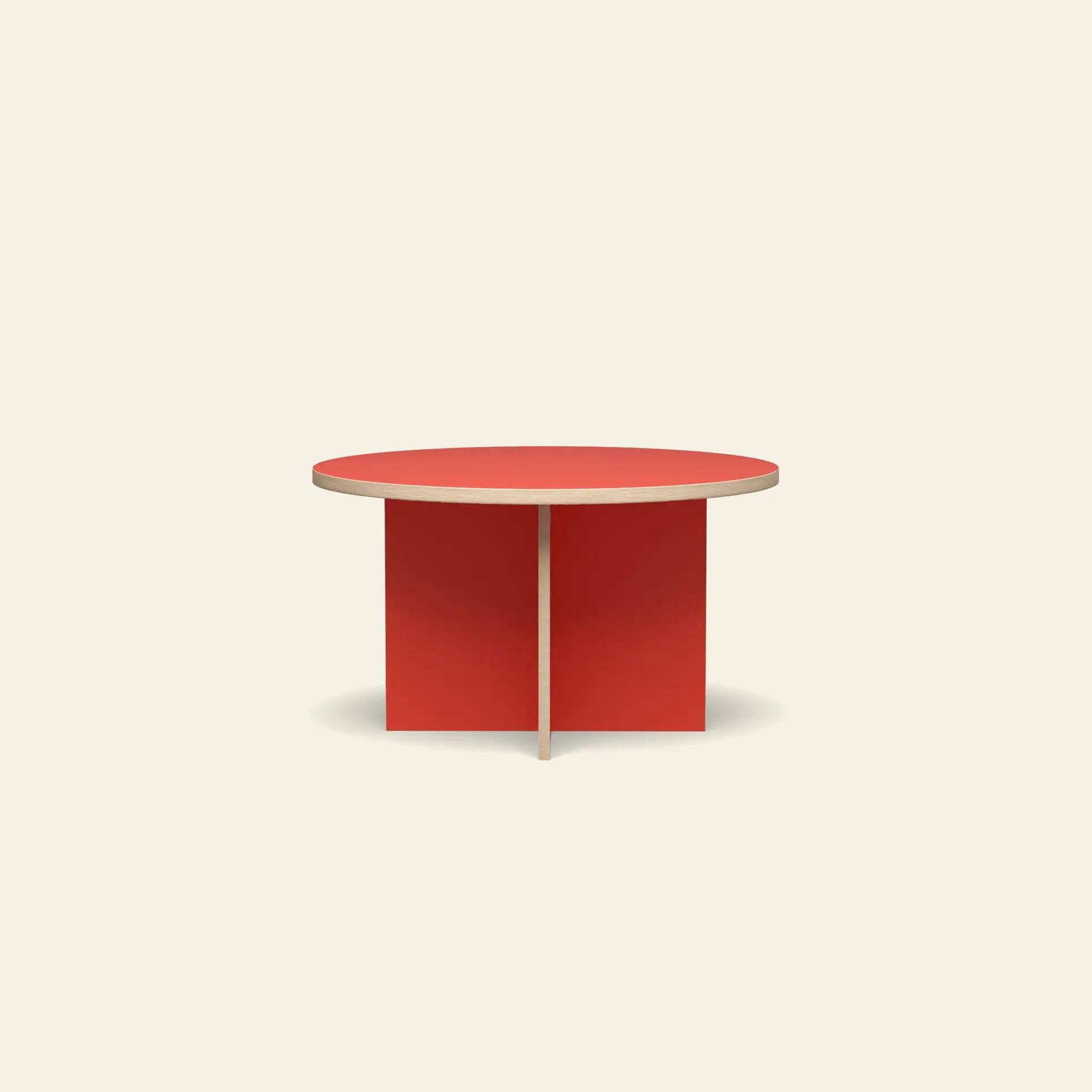 The HKLIVING Dining Table, Round, 130cm by HKLIVING features a vibrant red top and intersecting base, creating a striking look against an off-white background.