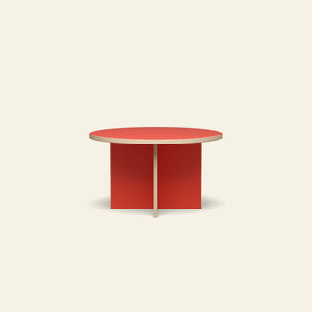 The HKLIVING Dining Table, Round, 130cm by HKLIVING features a vibrant red top and intersecting base, creating a striking look against an off-white background.