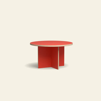 The HKLIVING Dining Table, Round, 130cm features a striking red top and intersecting red flat panel legs, making it a bold centerpiece against any light beige background.