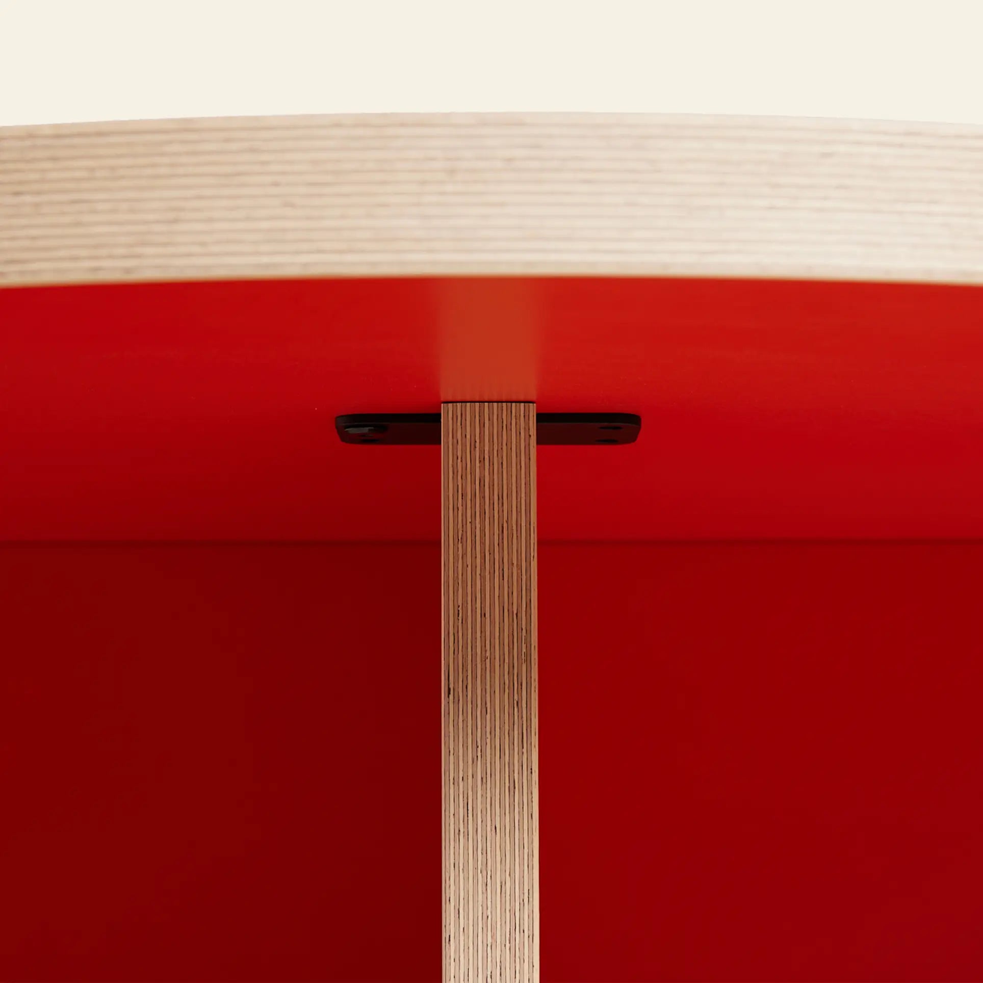 Close-up of the HKLIVING Dining Table, Round, 130cm, showing its light wood tabletop and red underside with a focus on the connection to the vertical wooden support—a stylish centerpiece for contemporary dining rooms.