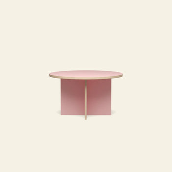The HKLIVING Dining Table is a modern, round 130cm table with a light pink top and intersecting pink panel legs by HKLIVING, shown against a plain beige background.