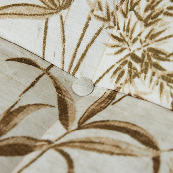 Close-up of the HKLIVING Lazy Lounge Bench by HKLIVING, featuring beige fabric with brown botanical prints, detailed with a seam and a fabric-covered button at the intersection.