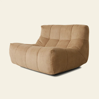 The HKLIVING Lazy Lounge Chair Corduroy by HKLIVING is a large, modern tan lounge chair with a low, wide seat and plush quilted cushioning, capturing retro comfort and style against a plain light background.