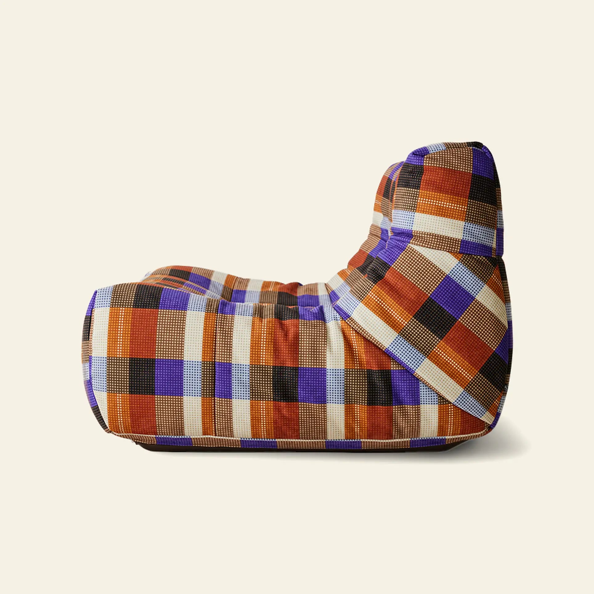 The HKLIVING Lazy Lounge Chair by HKLIVING features a bean bag-inspired silhouette and generous cushioning, upholstered in playful prints—a striking plaid of orange, blue, black, and beige squares on a cream background.