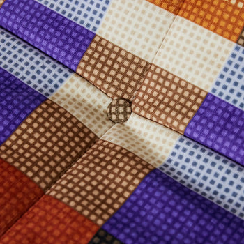 Close-up of the HKLIVING Lazy Lounge Chair by HKLIVING, featuring a cushioned seat with a checkered pattern in brown, beige, orange, and purple squares, playful prints, and a central button covered in matching fabric.