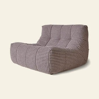 The HKLIVING Lazy Lounge Chair by HKLIVING is a modern, armless lounge chair with a tufted seat and backrest, featuring black and white houndstooth upholstery on a plain light background.