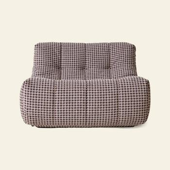 The HKLIVING Lazy Lounge Chair by HKLIVING features a modern armless design, low wide seat, and tufted black-and-white houndstooth upholstery that adds playful style to any room.