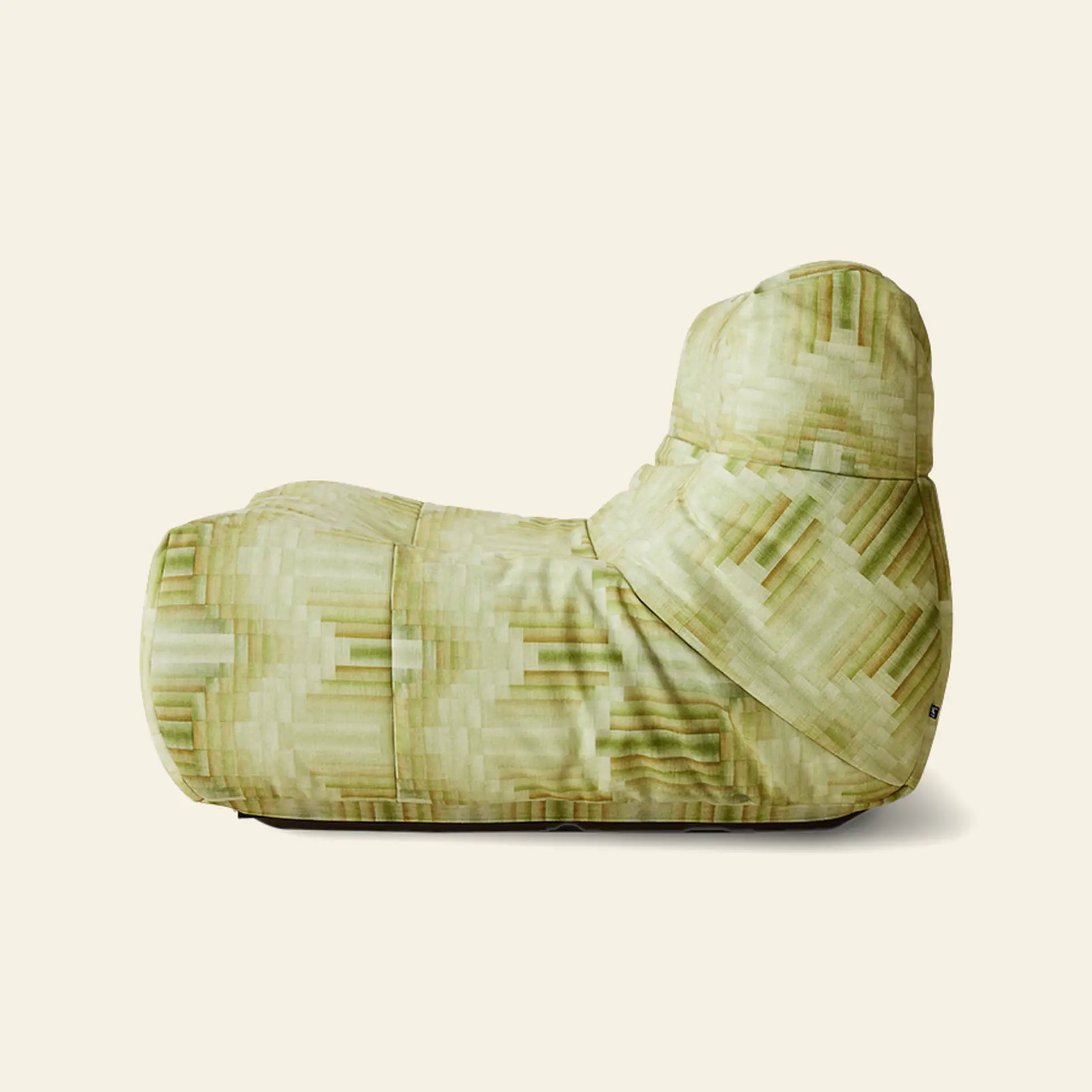 The HKLIVING Lazy Lounge Chair by HKLIVING features a soft, relaxed shape and cushioned high backrest, shown in profile. Its geometric pixelated pattern comes in playful green prints against a plain beige background.
