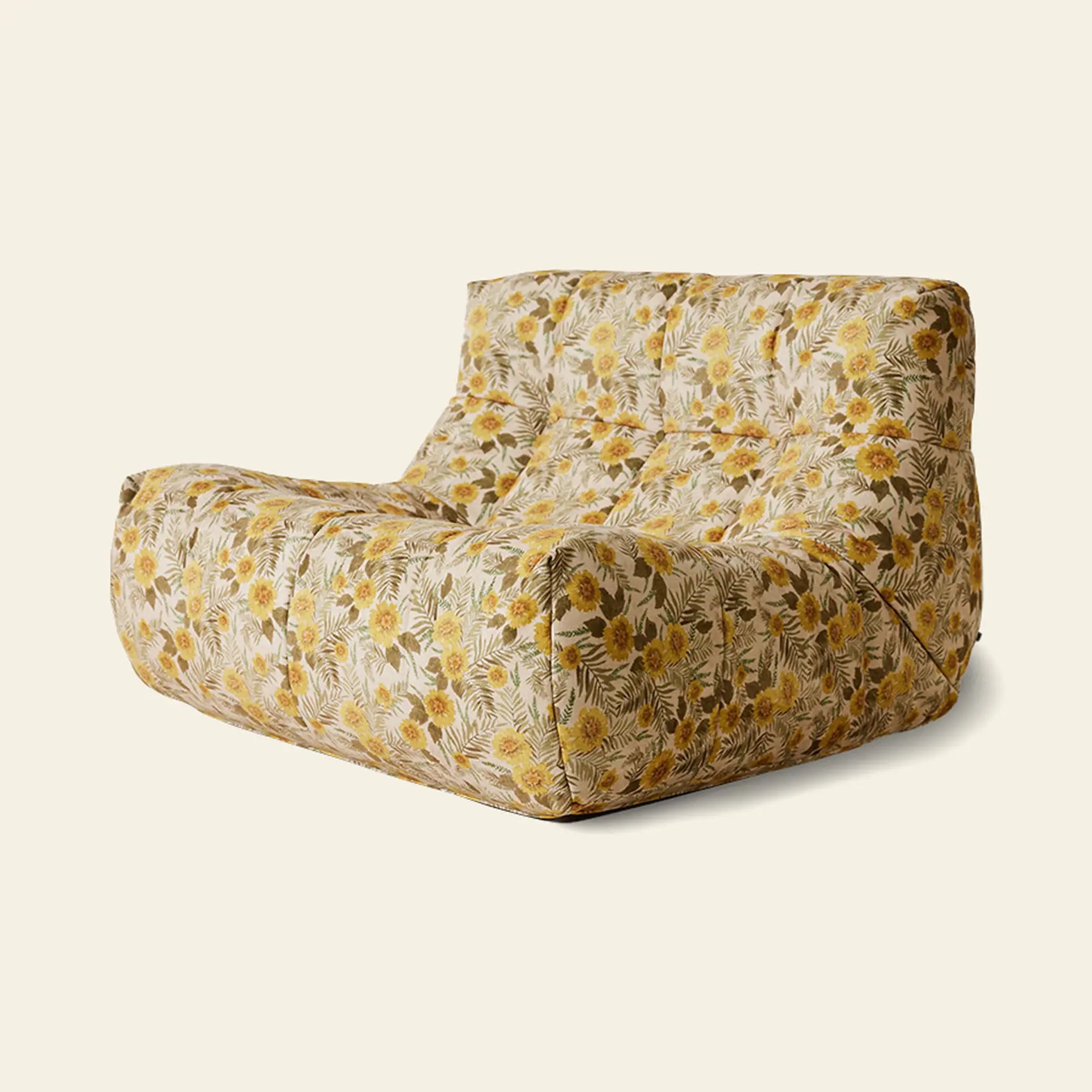 The HKLIVING Lazy Lounge Chair by HKLIVING is a modern, armless seat with playful yellow, green, and brown prints. Its plush tufted design and relaxed shape stand out against a plain beige background.