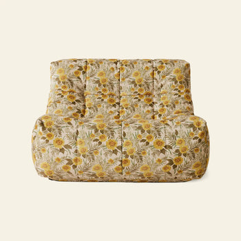 The HKLIVING Lazy Lounge Chair by HKLIVING features a plush, armless design with playful vintage-style floral prints in yellow, green, and beige on a light off-white background.