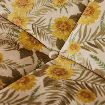 Close-up of the HKLIVING Lazy Lounge Chair by HKLIVING, showing its tufted cushioned seat with beige fabric adorned with yellow sunflower and green fern prints, completed with a button at the seam intersection.