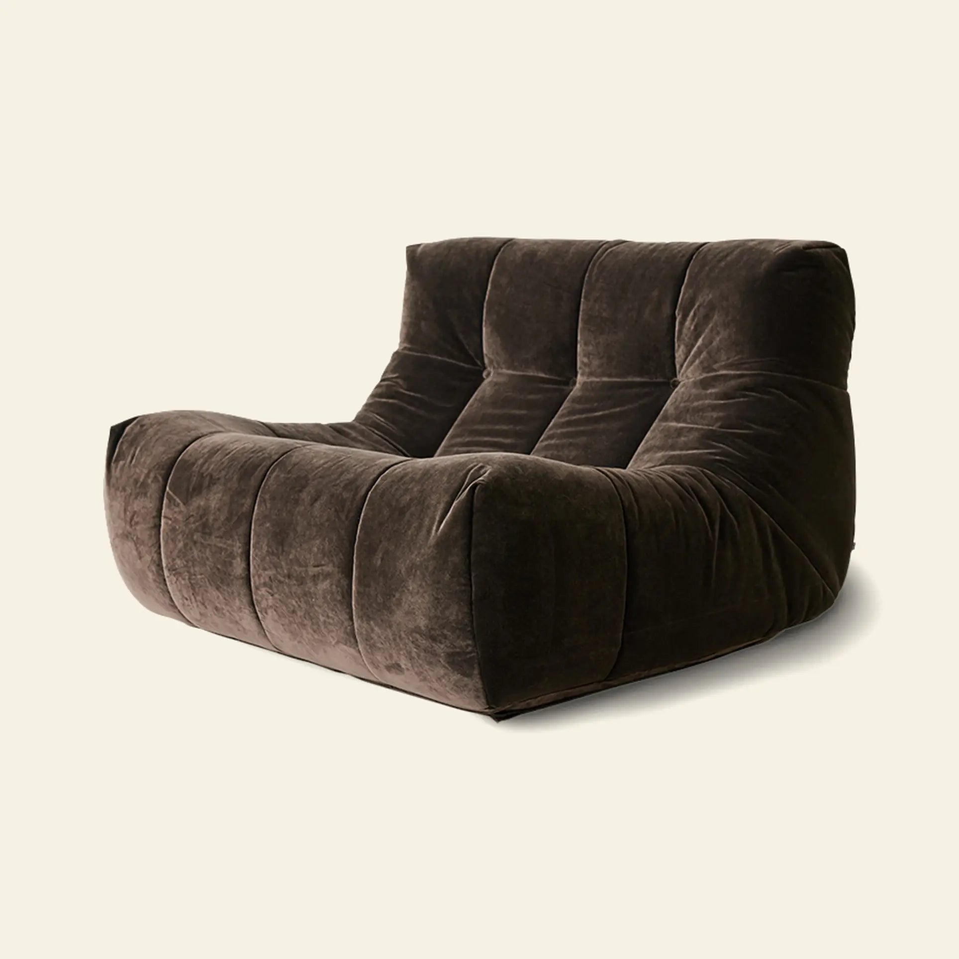 The HKLIVING Lazy Lounge Chair by HKLIVING features a low, wide design with brown velvet upholstery and deep tufted cushions, offering modern comfort and style, ideal for pairing with playful prints against any light background.