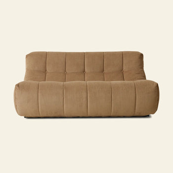 The HKLIVING Lounge Bench Corduroy by HKLIVING features a modern, low-profile design in brown corduroy with wide seat cushions, a tufted backrest, and soft rounded edges, shown against a plain off-white background.