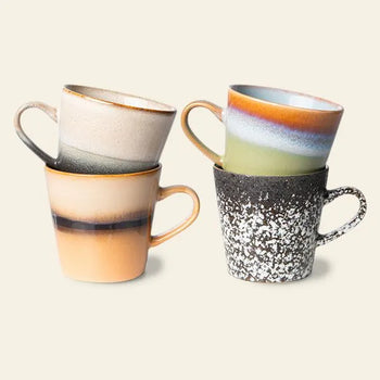 The HKLIVING 70s Ceramics: Americano Mugs, Set of 4 features hand-glazed stoneware mugs in earth tones with unique speckled, ombre, and gradient designs, stacked in pairs against a light beige backdrop.