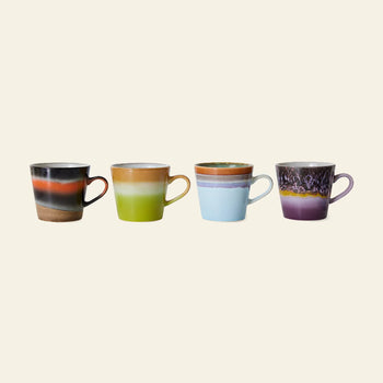 The HKLIVING 70s Ceramics Cappuccino Mugs Set of 4 features hand-glazed mugs in unique patterns and glazes—black/orange, green/beige, blue/brown, and purple with a textured 70s design—all with handles.
