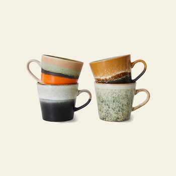 The HKLIVING 70s Ceramics Cappuccino Mugs Set of 4 features unique, hand-glazed mugs with rustic color combinations and sturdy handles, inspired by 70s ceramics and presented in earthy tones.
