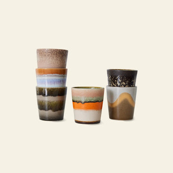 The HKLIVING 70s Ceramics: Coffee Mugs, Set of 6 by HKLIVING features handcrafted, earth-toned mugs with vintage textures, arranged with three stacked on the left and three upright on the right against a plain light background.