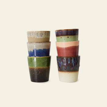 The HKLIVING 70s Ceramics Coffee Mugs set includes six unique, handcrafted mugs in earthy and vibrant tones, each inspired by 70s design and stacked in two uneven columns against a plain light background.