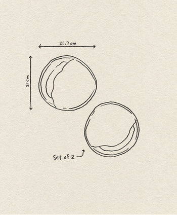 A simple line drawing of two HKliving 70s Ceramics Curry Bowls (set of 2), each approx. 21.7 cm wide and 21 cm tall, appears on a textured beige background with arrows marking their size—a subtle vintage touch.