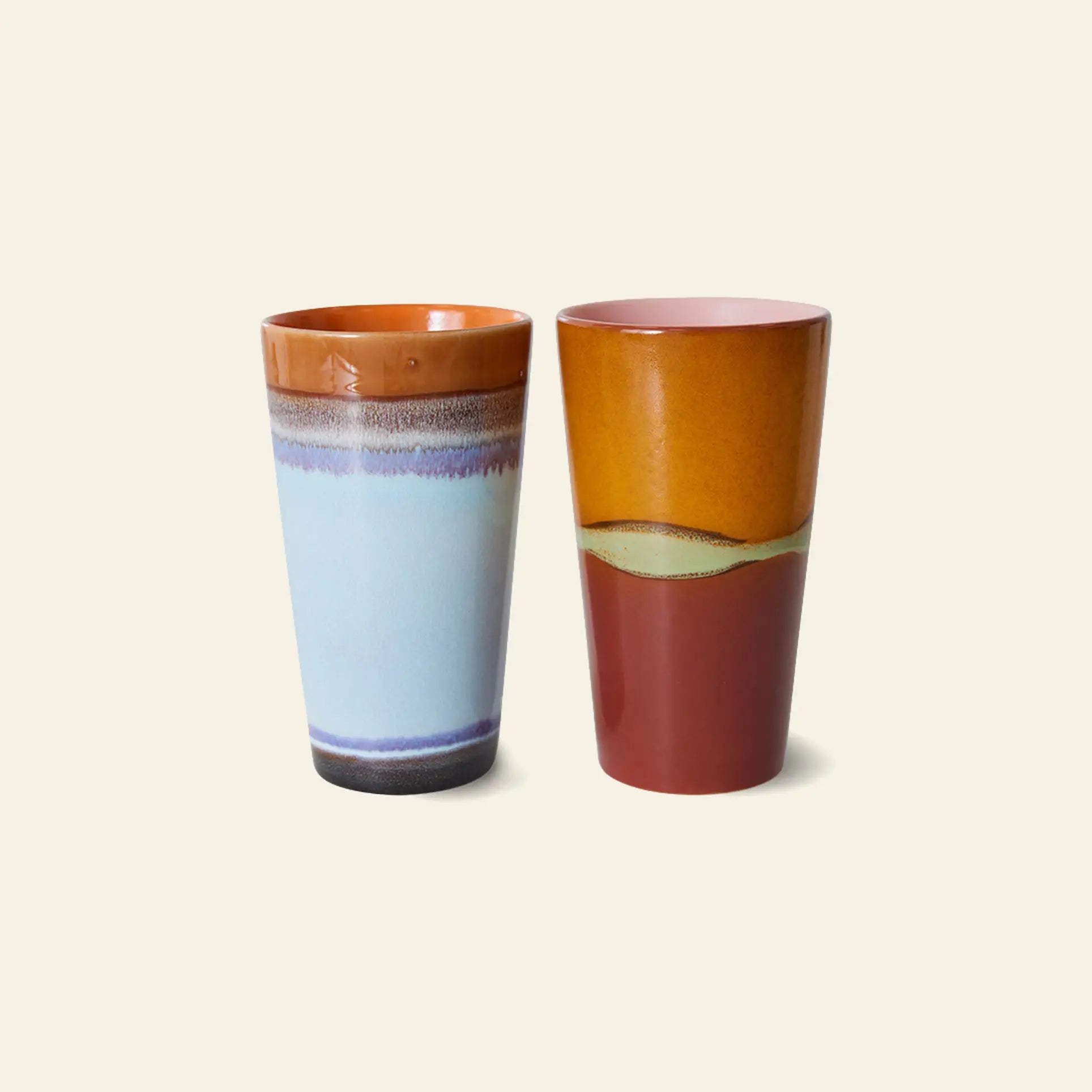 HKLIVING 70s Ceramics: Latte Mugs, Set of 2 by HKLIVING—two tall ceramic mugs in glossy, handcrafted glaze. One features blue, white, and brown gradients; the other has orange, yellow, and red-brown bands for a vibrant retro look.