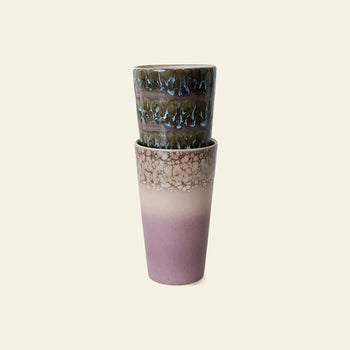The HKLIVING 70s Ceramics Latte Mugs Set of 2 features one mug with a handcrafted brown, blue, and green glaze stacked atop another with a pink and beige gradient plus crackle pattern, both displayed against a plain light background.