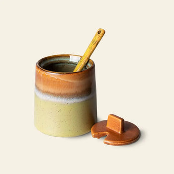 The HKLIVING 70s Ceramics: Milk Jug & Sugar Pot set by HKLIVING features a ceramic sugar pot with a gradient brown and beige glaze, matching lid with spoon cutout, and a small wooden spoon—evoking classic 70s style.