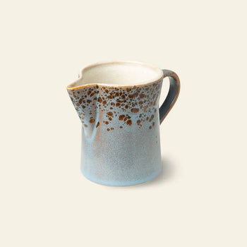 The HKLIVING 70s Ceramics: Milk Jug & Sugar Pot features a blue ceramic milk jug with handle, spout, and brown speckled rim, reflecting vintage 70s style against a plain light backdrop.