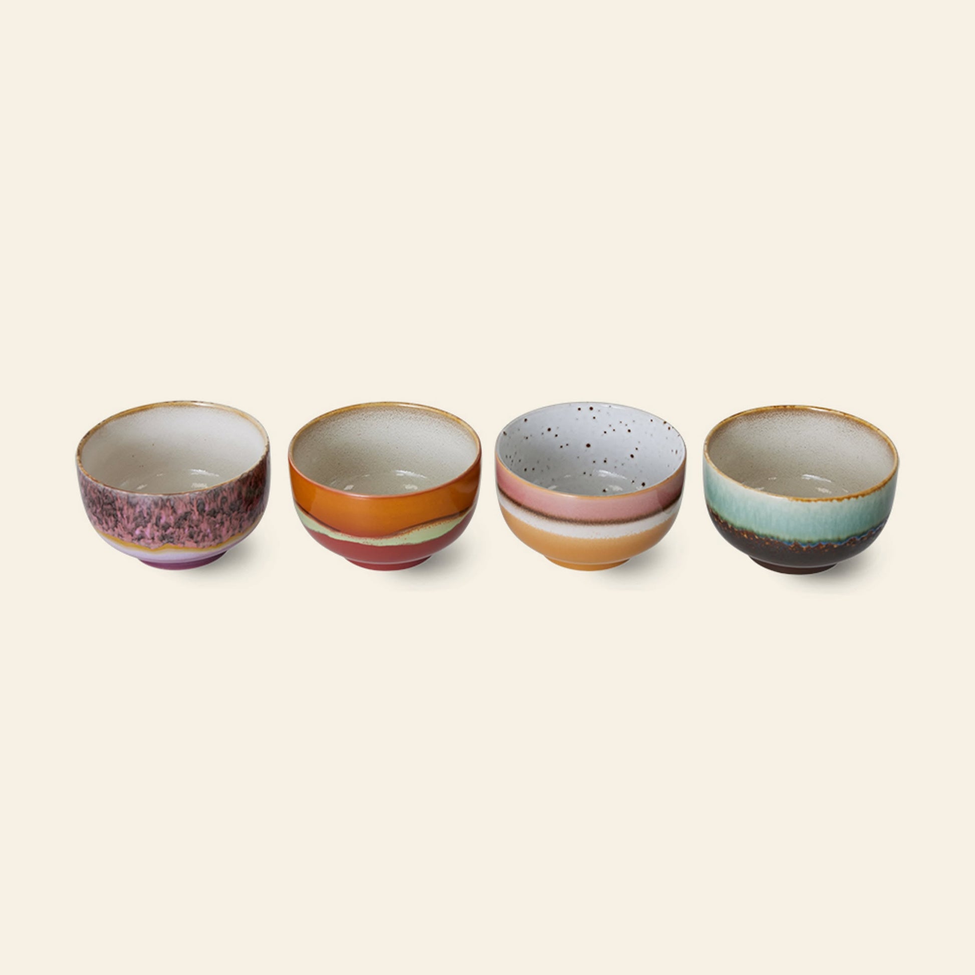 The HKLIVING 70s Ceramics: Noodle Bowls, Set of 4 features four stoneware bowls in unique colors and designs—pink, orange, speckled white with stripes, and green-blue with brown—displayed in a row on a light background.