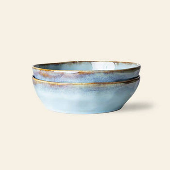 The HKliving 70s Ceramics: Pasta Bowls, Set of 2, feature a glossy blue and brown glaze—ideal for an elegant table setting and shown stacked against a plain beige background.