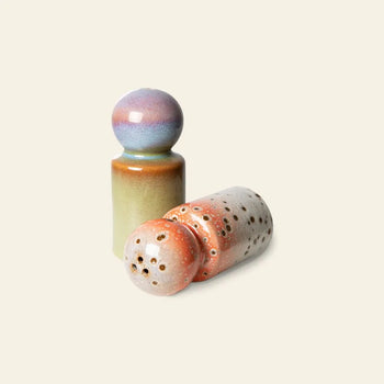 The HKLIVING 70s Ceramics: Pepper & Salt Jar set by HKLIVING features retro kitchenware in Asteroids/Peats colors—one upright in blue, purple, and green, the other lying down with a speckled orange and white pattern.